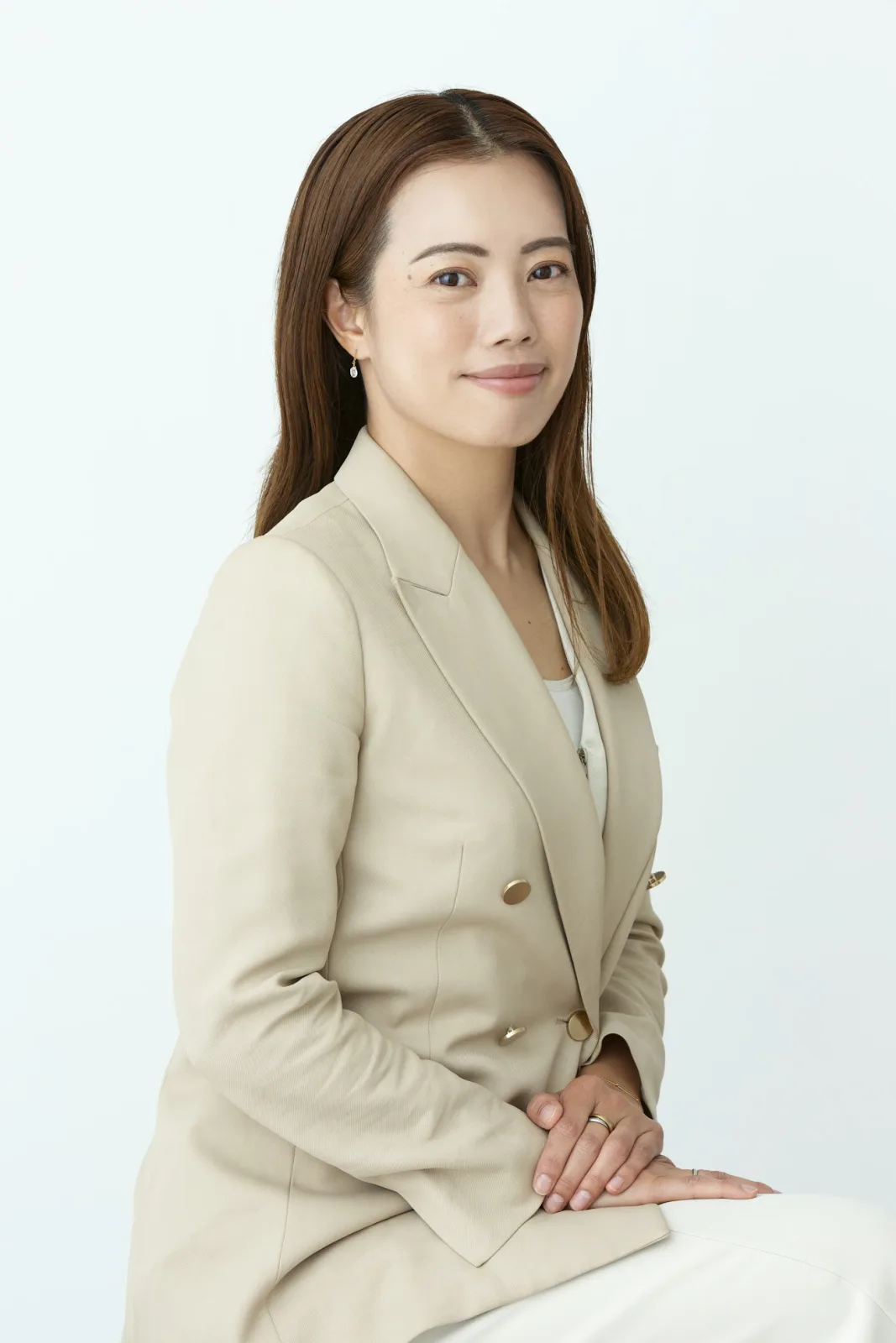 ベージュのスーツ姿の井上かな映